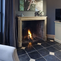 Black Belgian Antique Marble Surface with Cabochon and Antique fireplace surround in dining room.