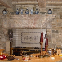 A Kitchen with a Great Vintage French Limestone Fireplace Surround and a La Cornue.  